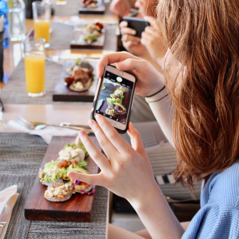 woman taking a selfie of food on a food tour