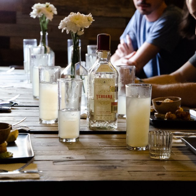 a person sitting at a table with food and drinks